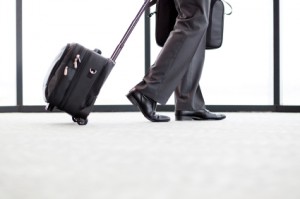 businessman walking in airport with his luggage